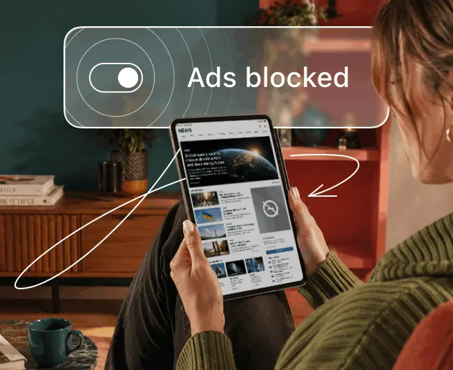 A person holding a tablet with an overlay displaying a toggle switch and the text Ads blocked.