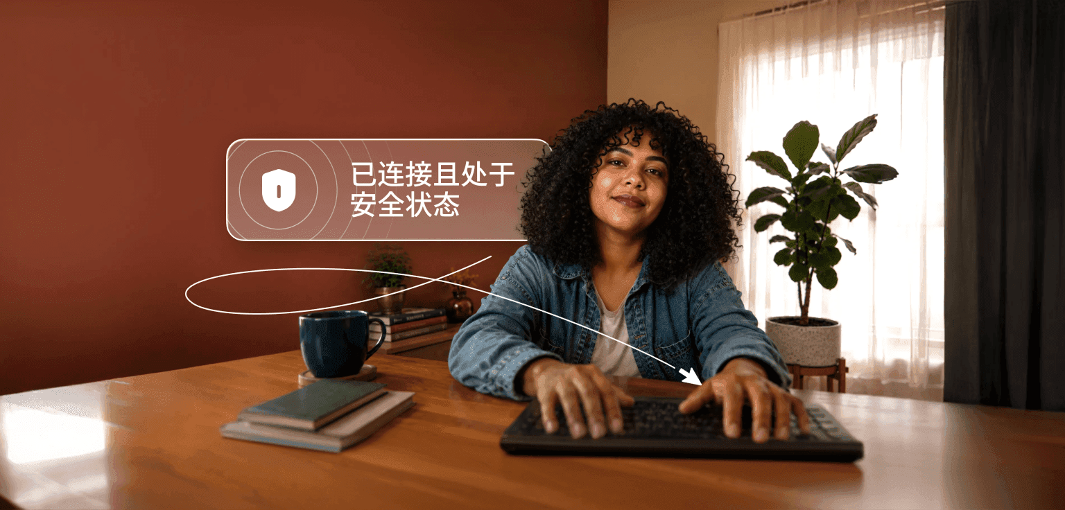 一个卷发人士正在办公桌前用笔记本电脑打字,笔记本上方的对话气泡写着“已连接且安全”。