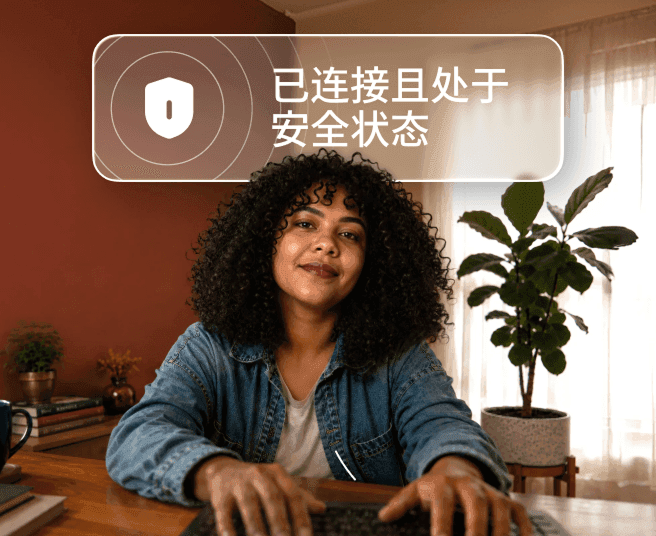 一个卷发人士正在办公桌前用笔记本电脑打字,笔记本上方的对话气泡写着“已连接且安全”。