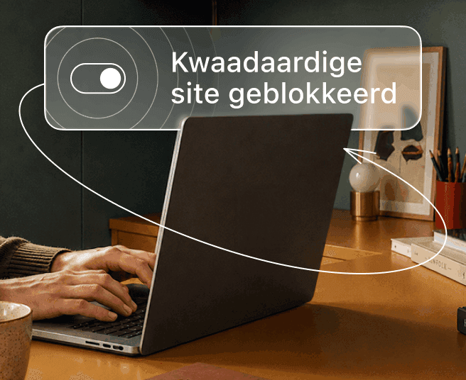 Een persoon typt op een laptop terwijl een digitale overlay een schakelaar en de tekst 'Kwaadaardige site geblokkeerd' weergeeft.