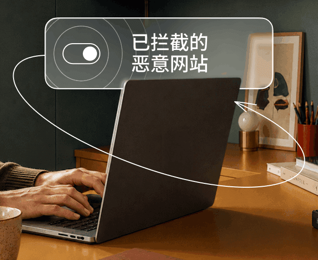 一个人正在笔记本电脑上打字,屏幕浮层显示切换开关和“已拦截恶意网站”字样。