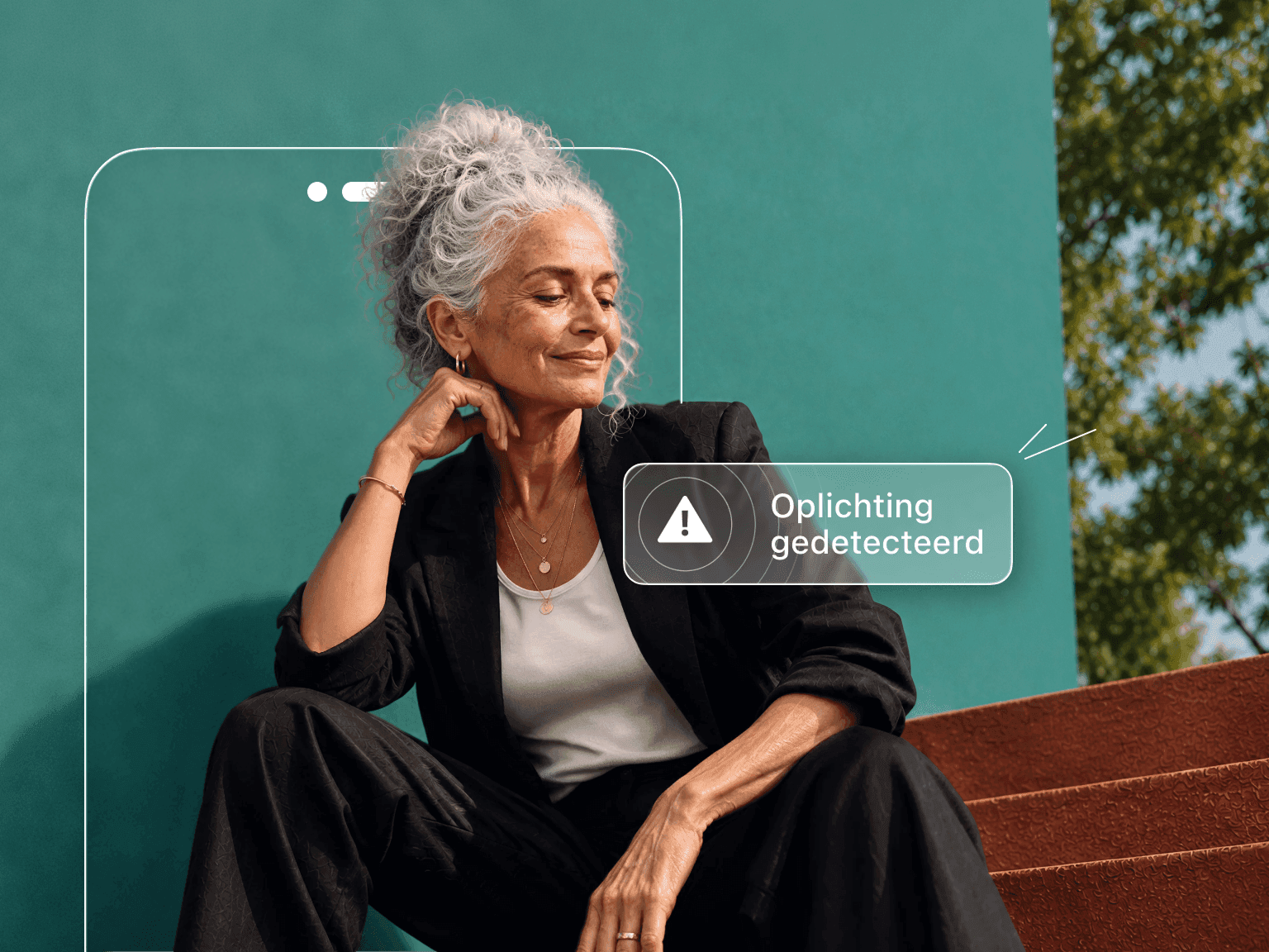 Een vrouw met grijs haar zit tegen een blauwgroene muur, deels verborgen door een telefoonomtrek die een waarschuwing 'Oplichting gedetecteerd' toont.